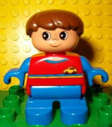 Duplo Figure, Child Type 2 Boy, Blue Legs, Red Top with Yellow and Blue Stripes and Yellow Car Logo, Blue Arms, Brown Hair 